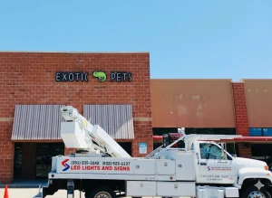 Exotic Pets store with a vibrant sign being installed by a top custom signs Houston provider using a lift truck.