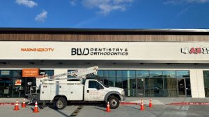 Bucket truck installing signage at BLVD Dentistry & Orthodontics, featuring building signs Houston for professional business displays.