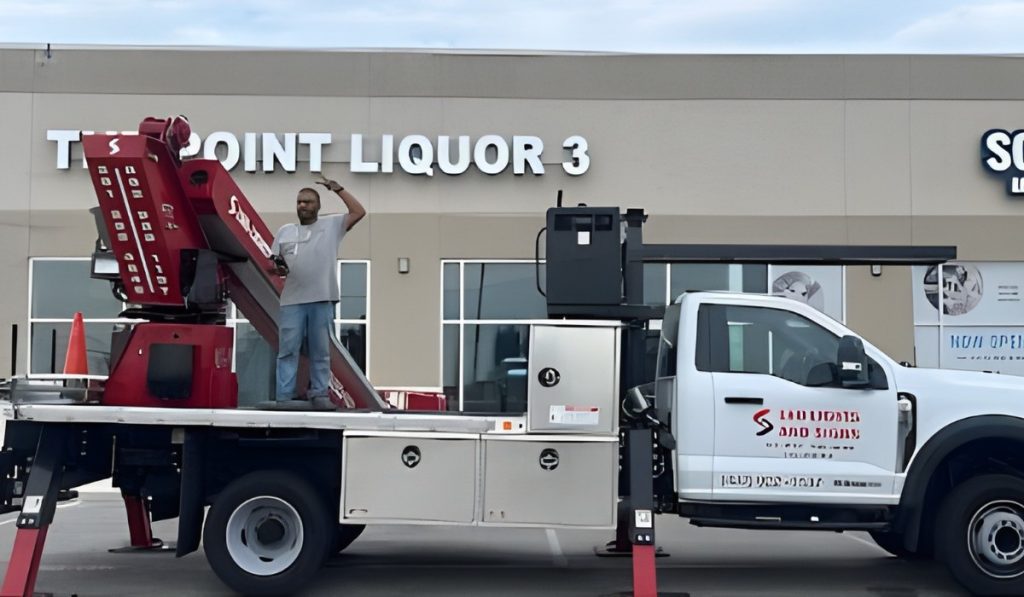 Technician on lift installing a liquor store sign with a Signage Company Houston, offering expert signage services.