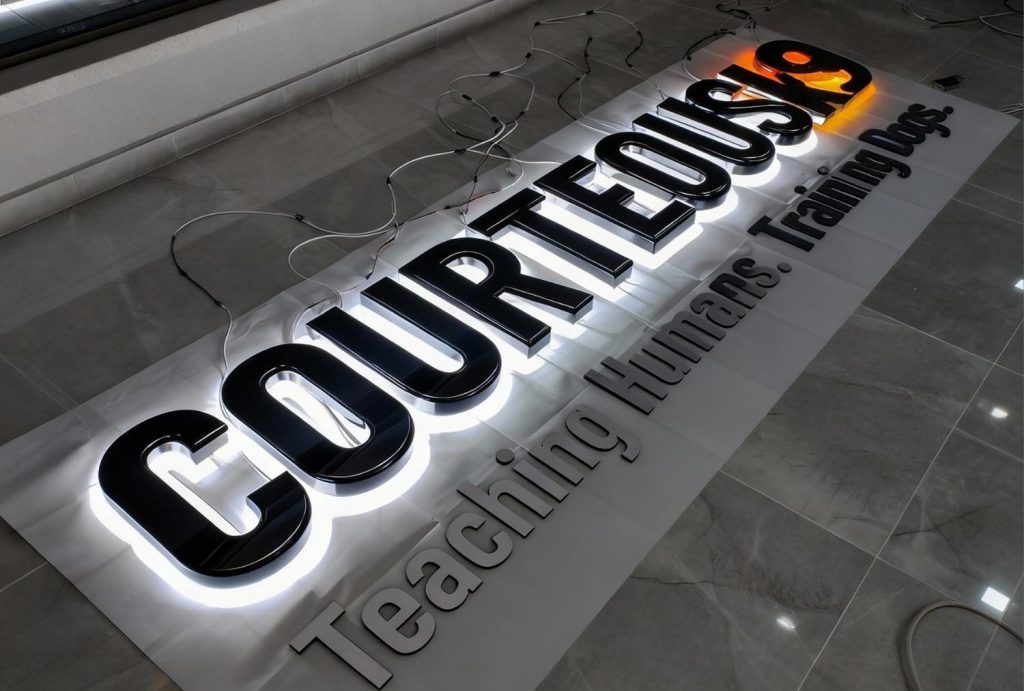 Bold black acrylic backlit storefront signage houston for Courteous K9 – reverse halo lit letters with clean white glow during final testing