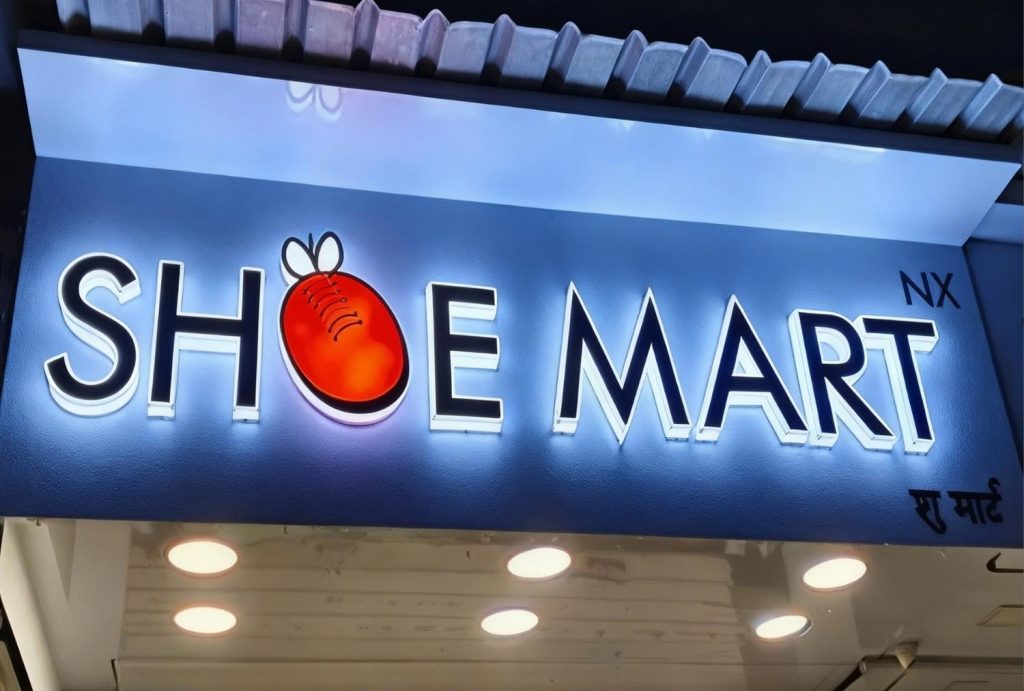 Vibrant custom signs Houston – Shoe Mart NX illuminated 3D channel letters with glowing white halo effect and playful red shoe logo