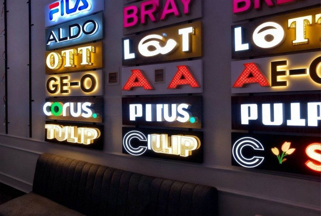 Wall display of premium custom LED lightbox signs houston featuring halo-lit channel letters for top brands
