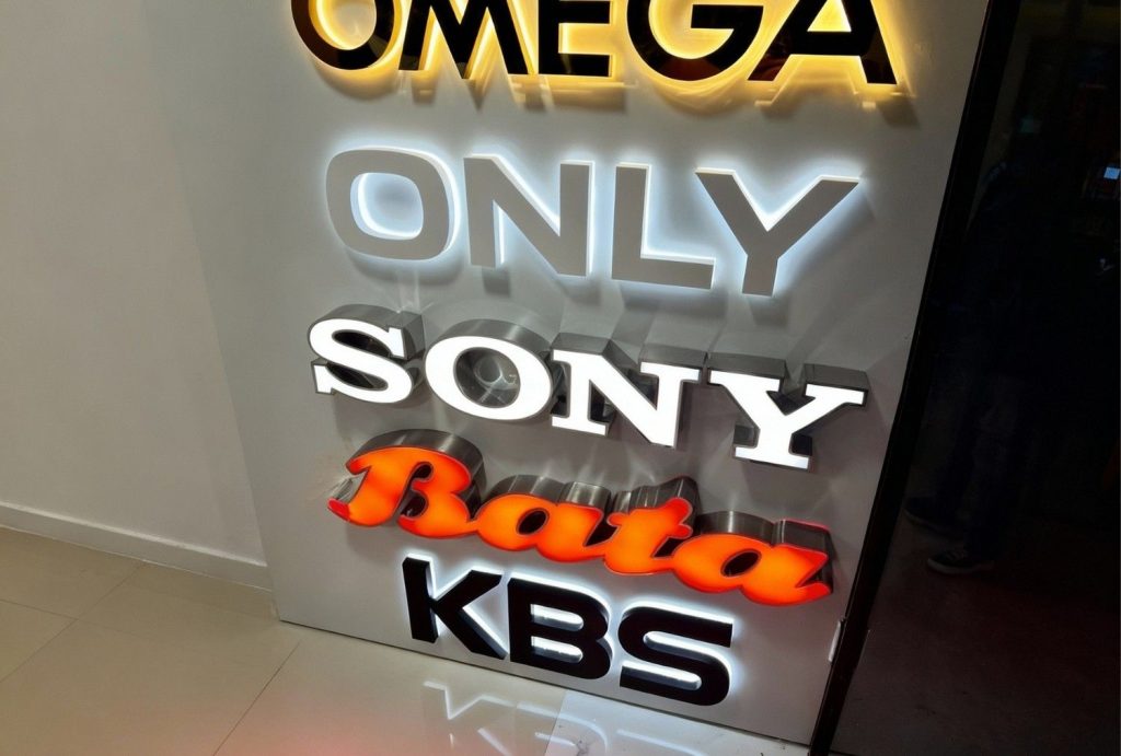 High-end custom business storefront signs Houston featuring Omega, Sony, Bata, and KBS logos with LED halo lighting
