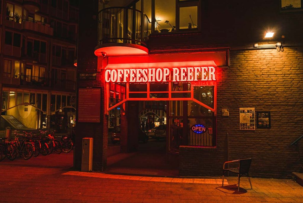 Custom red neon business sign manufactured by a Houston sign company, advertising a coffeeshop at night.