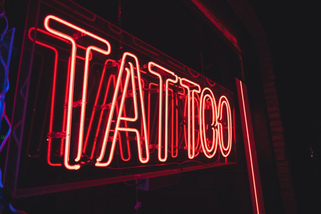 Red neon tattoo shop sign by a leading provider of custom signs Houston residents use for bold business branding