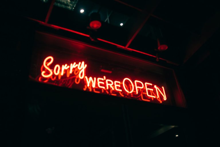Creative Sorry We're Open red neon window display, showcasing high quality custom signs Houston businesses prefer.