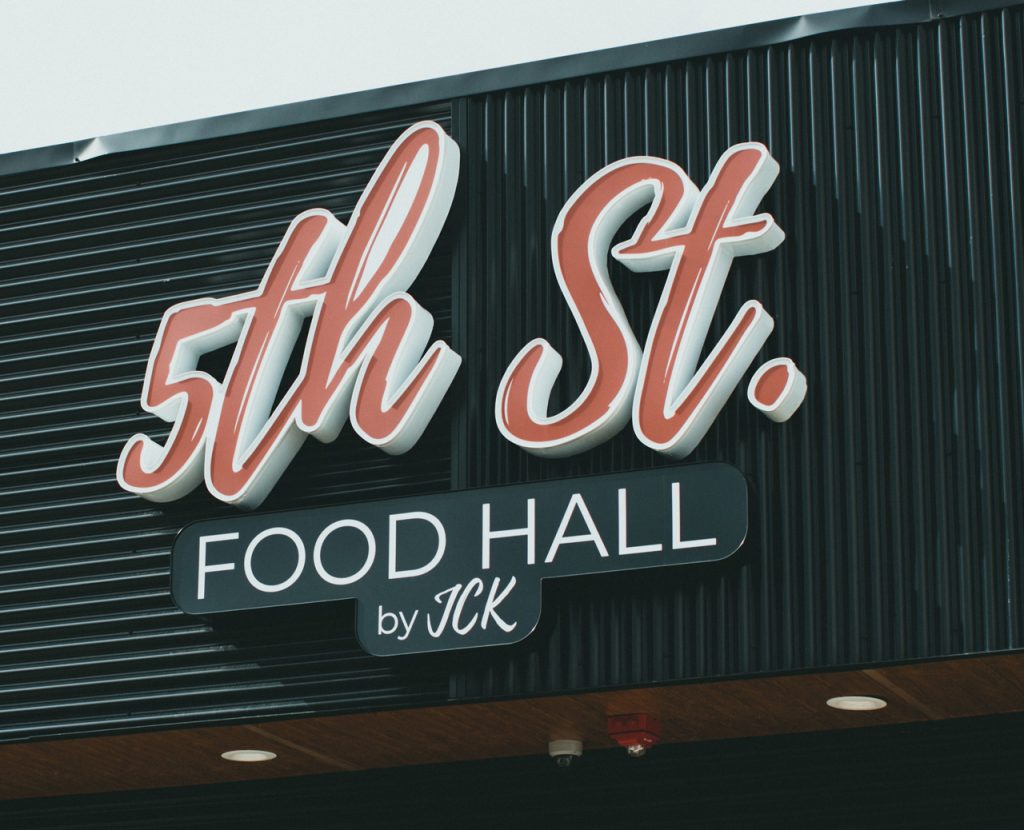 Custom neon script outdoor signs for businesses Houston food hall featuring red illuminated 5th St. channel letters.
