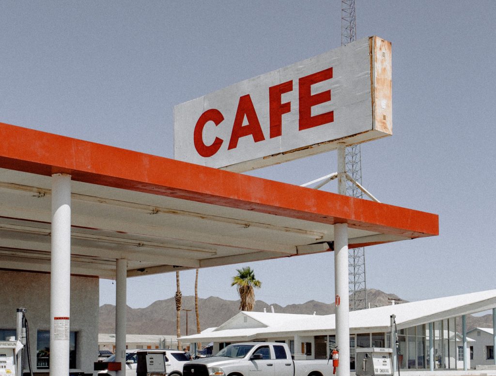 Retro roadside cafe outdoor signs for businesses Houston style featuring a large weathered red painted monument sign.