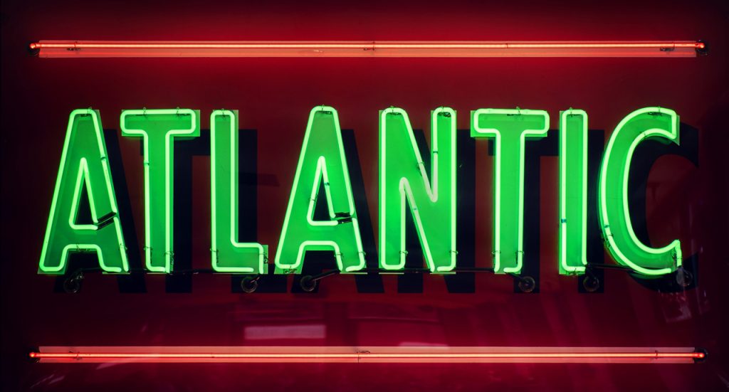 Vibrant green Atlantic neon sign with red borders created by an expert manufacturer of custom signs Houston area.