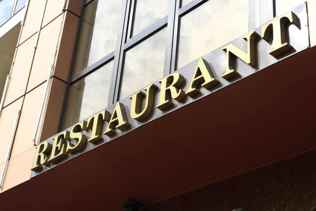 Custom gold brass dimensional letters for restaurant wall branding installed by a professional signage company Houston.