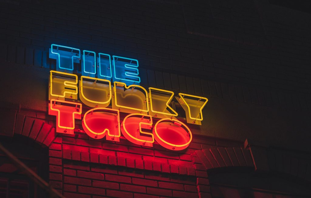 The Funky Taco custom neon sign by a business sign manufacturer Houston businesses use for outdoor lighted signage.