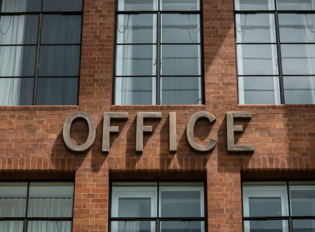 Metal dimensional letters for an office building wall mounted by a professional sign manufacturer Houston expert.