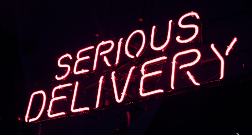 Bright red Serious Delivery neon lettering crafted by a professional shop specializing in custom signs Houston Texas.