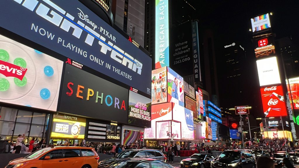 Bright LED displays for Houston commercial signs featuring Sephora and Disney ads above a crowded urban plaza.