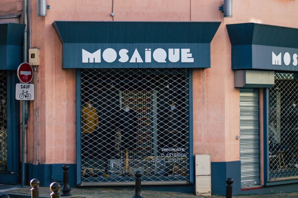 Modern Mosaïque storefront with a blue awning, a prime example of custom houston commercial signs for retail boutiques.