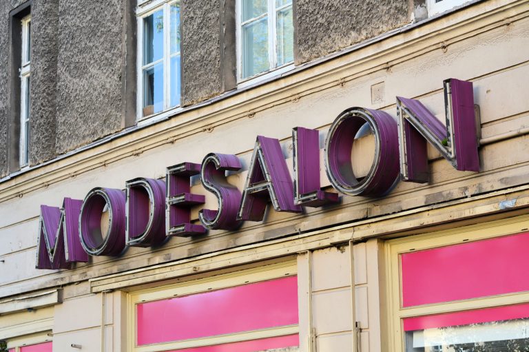 Vintage purple neon lettering for Modesalon, highlighting artistic houston commercial signs with a retro aesthetic.