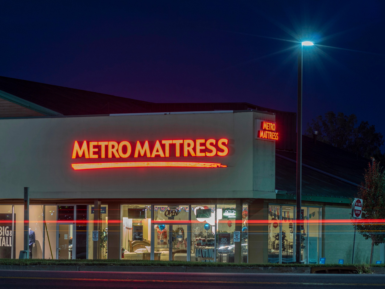 Illuminated red storefront channel letters for Metro Mattress, expertly crafted by a sign manufacturing Houston company.