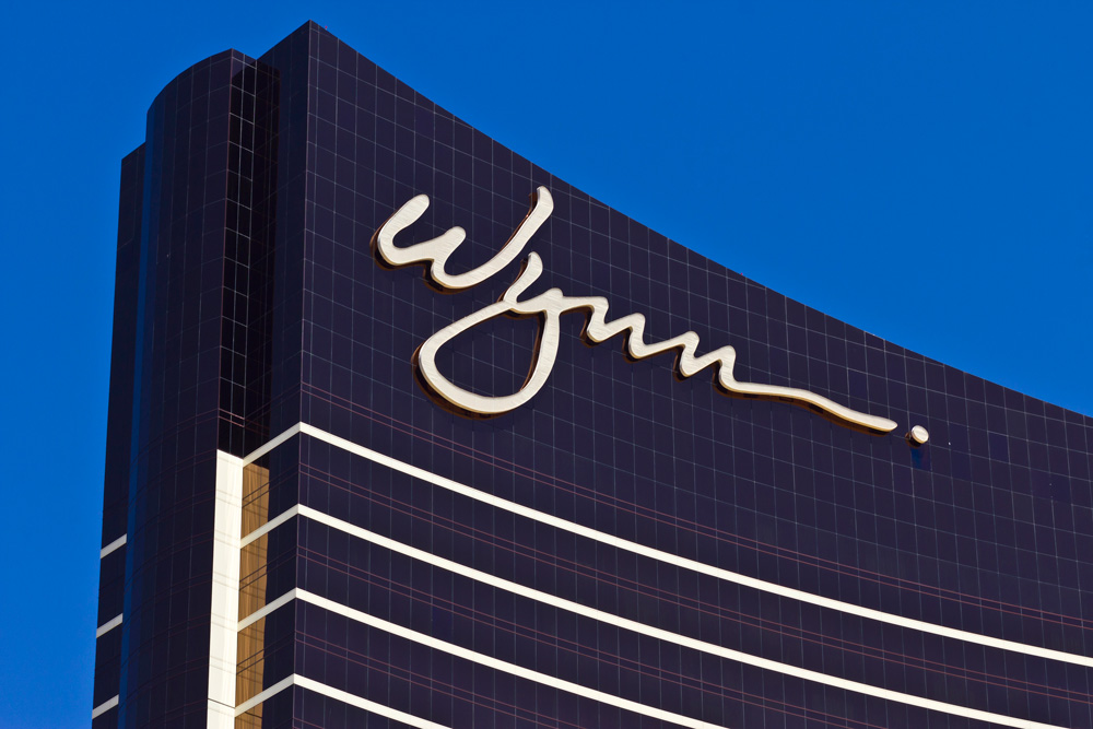 Modern retail signs Houston style featuring the iconic gold Wynn logo on a sleek dark glass resort skyscraper.