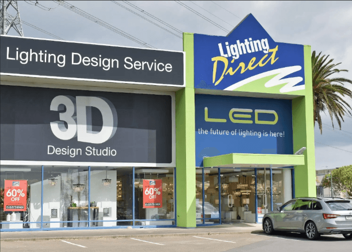 Large building facade and storefront signage produced by a sign manufacturer Houston for a commercial lighting store.