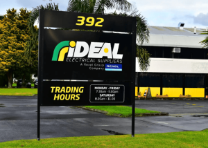 Freestanding pylon business sign with trading hours from a sign manufacturer Houston for an electrical supplier.