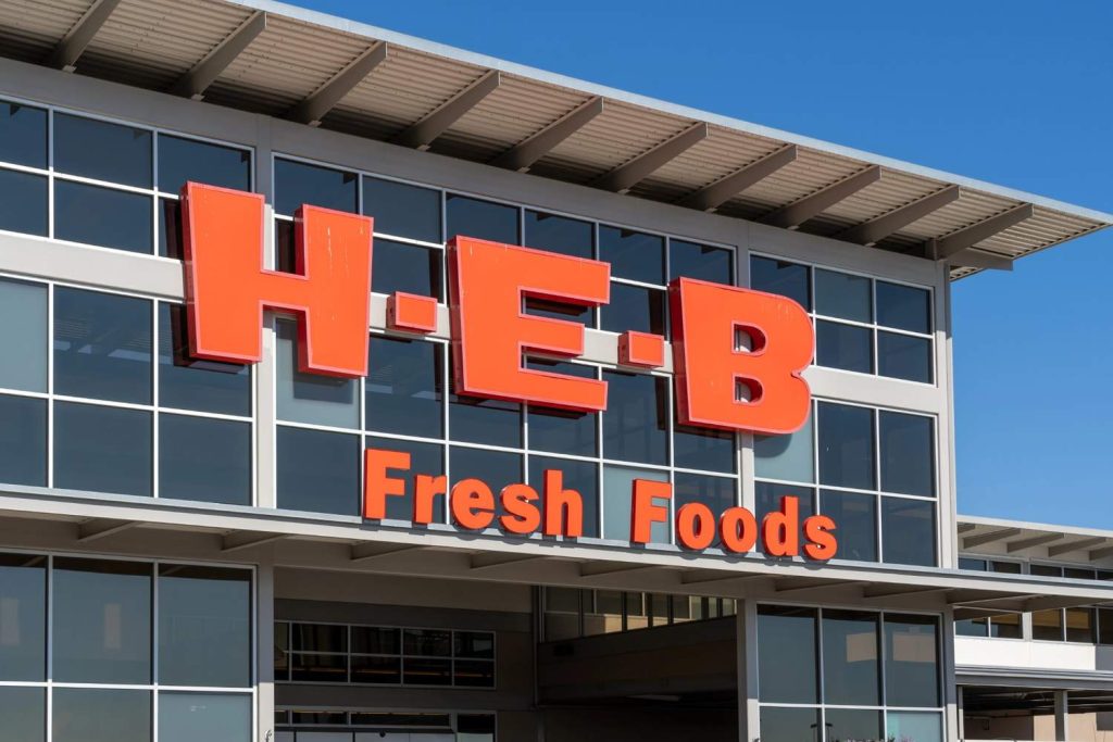 Large scale outdoor H-E-B grocery store branding installed by a professional business sign manufacturer Houston. 