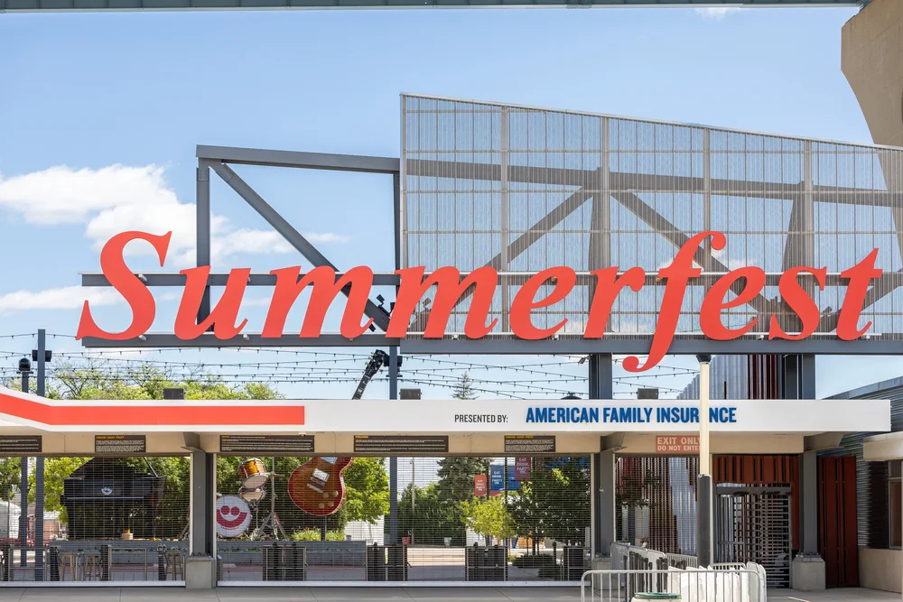Large red script Summerfest sign above a steel mesh entrance gate structure, showcasing significant Event Signage houston potential.