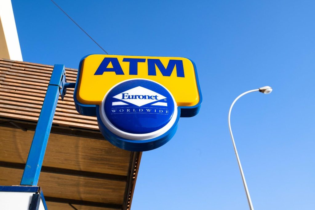Blue and yellow Euronet ATM roadside placard showing classic branding for Houston commercial signs outdoors. 