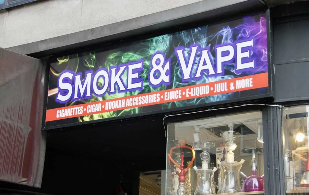 Custom channel letter signs Houston for a smoke shop storefront advertising vape ejuice and hookah accessories.