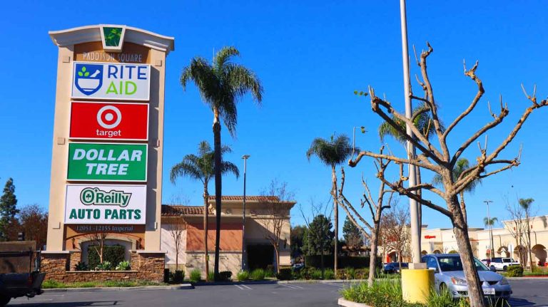 A tall retail pylon sign showcasing multiple brand business signs Houston drivers see when visiting local shopping plazas.